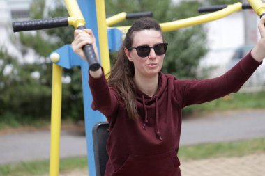 Kadın egzersiz yapıyor ya da dışarıda egzersiz yapıyor.