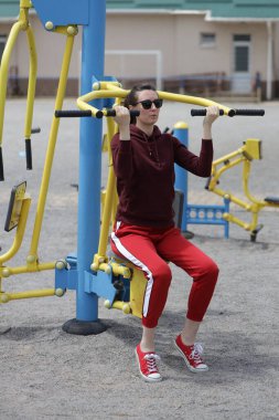 Kadın egzersiz yapıyor ya da dışarıda egzersiz yapıyor.