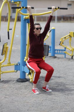 Kadın egzersiz yapıyor ya da dışarıda egzersiz yapıyor.