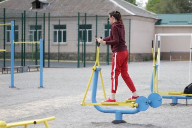 Kadın egzersiz yapıyor ya da dışarıda egzersiz yapıyor.