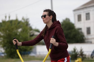 Kadın egzersiz yapıyor ya da dışarıda egzersiz yapıyor.