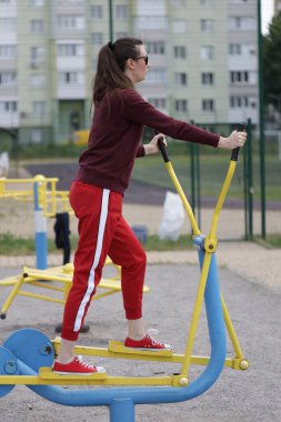 Kadın egzersiz yapıyor ya da dışarıda egzersiz yapıyor.