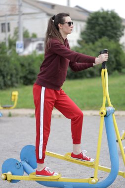 Kadın egzersiz yapıyor ya da dışarıda egzersiz yapıyor.