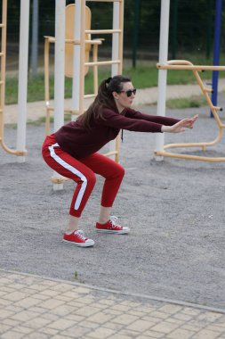 Kadın egzersiz yapıyor ya da dışarıda egzersiz yapıyor.