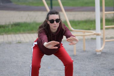 Kadın egzersiz yapıyor ya da dışarıda egzersiz yapıyor.