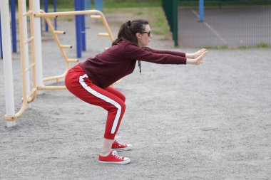 Kadın egzersiz yapıyor ya da dışarıda egzersiz yapıyor.