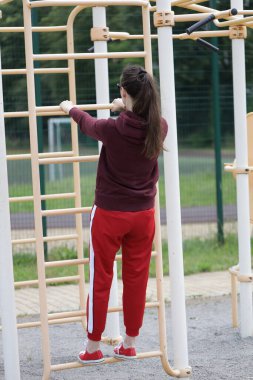 Kadın egzersiz yapıyor ya da dışarıda egzersiz yapıyor.