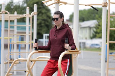 Kadın egzersiz yapıyor ya da dışarıda egzersiz yapıyor.