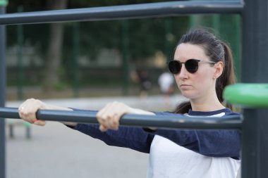 Kadın egzersiz yapıyor ya da dışarıda egzersiz yapıyor.