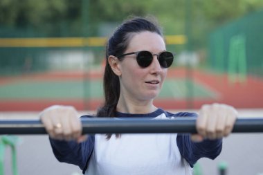 Kadın egzersiz yapıyor ya da dışarıda egzersiz yapıyor.