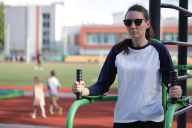 Kadın egzersiz yapıyor ya da dışarıda egzersiz yapıyor.