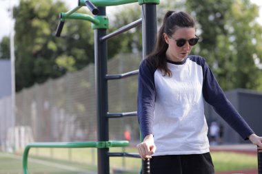 Kadın egzersiz yapıyor ya da dışarıda egzersiz yapıyor.