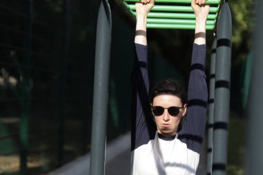 Kadın egzersiz yapıyor ya da dışarıda egzersiz yapıyor.