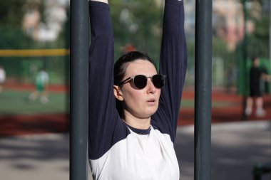 Kadın egzersiz yapıyor ya da dışarıda egzersiz yapıyor.