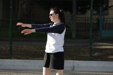 Kadın egzersiz yapıyor ya da dışarıda egzersiz yapıyor.