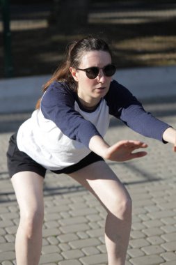 Kadın egzersiz yapıyor ya da dışarıda egzersiz yapıyor.