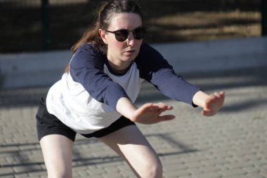 Kadın egzersiz yapıyor ya da dışarıda egzersiz yapıyor.