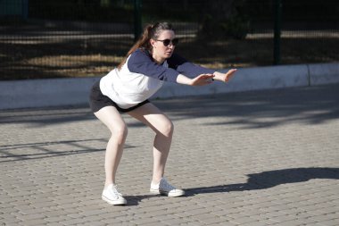 Kadın egzersiz yapıyor ya da dışarıda egzersiz yapıyor.