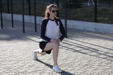 Kadın egzersiz yapıyor ya da dışarıda egzersiz yapıyor.