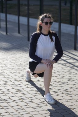 Kadın egzersiz yapıyor ya da dışarıda egzersiz yapıyor.