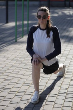 Kadın egzersiz yapıyor ya da dışarıda egzersiz yapıyor.