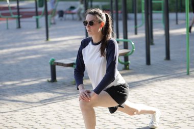 Kadın egzersiz yapıyor ya da dışarıda egzersiz yapıyor.