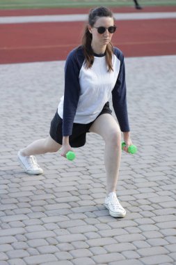 Kadın egzersiz yapıyor ya da dışarıda egzersiz yapıyor.