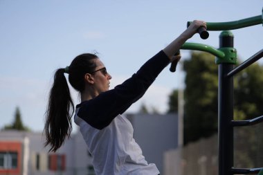 Kadın egzersiz yapıyor ya da dışarıda egzersiz yapıyor.