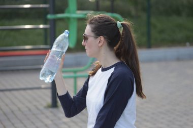 Kadın egzersiz yapıyor ya da dışarıda egzersiz yapıyor.