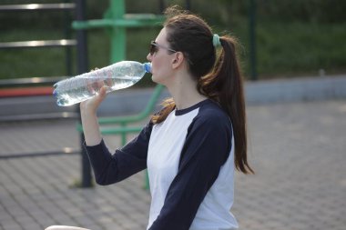 Kadın egzersiz yapıyor ya da dışarıda egzersiz yapıyor.