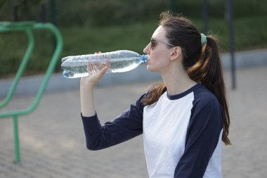 Kadın egzersiz yapıyor ya da dışarıda egzersiz yapıyor.