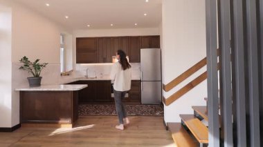 Modern bir özel evin oturma odasında bir kadın.