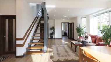 Modern bir özel evin oturma odasında bir kadın.