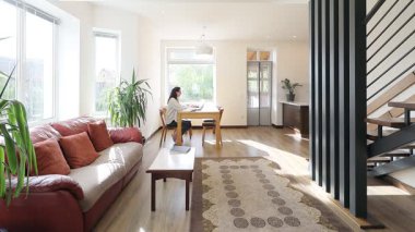 Modern bir özel evin oturma odasında bir kadın.