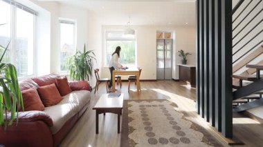 Modern bir özel evin oturma odasında bir kadın.