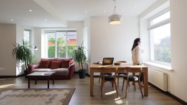 Modern bir özel evin oturma odasında bir kadın.