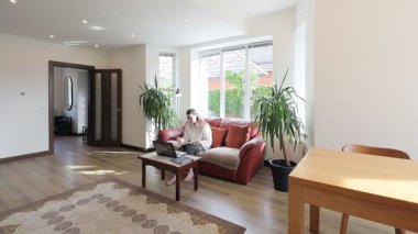 Modern bir özel evin oturma odasında bir kadın.