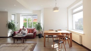 Modern bir özel evin oturma odasında bir kadın.