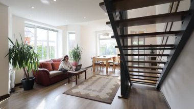 Modern bir özel evin oturma odasında bir kadın.