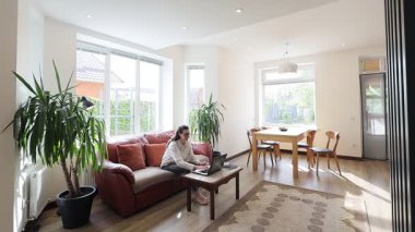 Modern bir özel evin oturma odasında bir kadın.