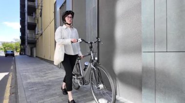 Eko çanta ya da pamuklu çanta taşıyan bir kadın şehirde bisiklet sürerken