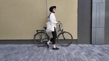 Eko çanta ya da pamuklu çanta taşıyan bir kadın şehirde bisiklet sürerken