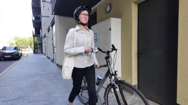 Eko çanta ya da pamuklu çanta taşıyan bir kadın şehirde bisiklet sürerken