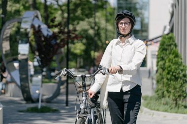 Eko çanta ya da pamuklu çanta taşıyan bir kadın şehirde bisiklet sürerken