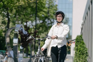 Eko çanta ya da pamuklu çanta taşıyan bir kadın şehirde bisiklet sürerken