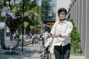 Eko çanta ya da pamuklu çanta taşıyan bir kadın şehirde bisiklet sürerken