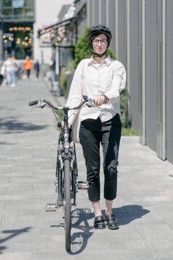 Eko çanta ya da pamuklu çanta taşıyan bir kadın şehirde bisiklet sürerken