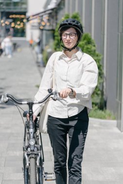 Eko çanta ya da pamuklu çanta taşıyan bir kadın şehirde bisiklet sürerken