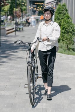 Eko çanta ya da pamuklu çanta taşıyan bir kadın şehirde bisiklet sürerken