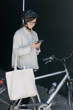 Eko çanta ya da pamuklu çanta taşıyan bir kadın şehirde bisiklet sürerken